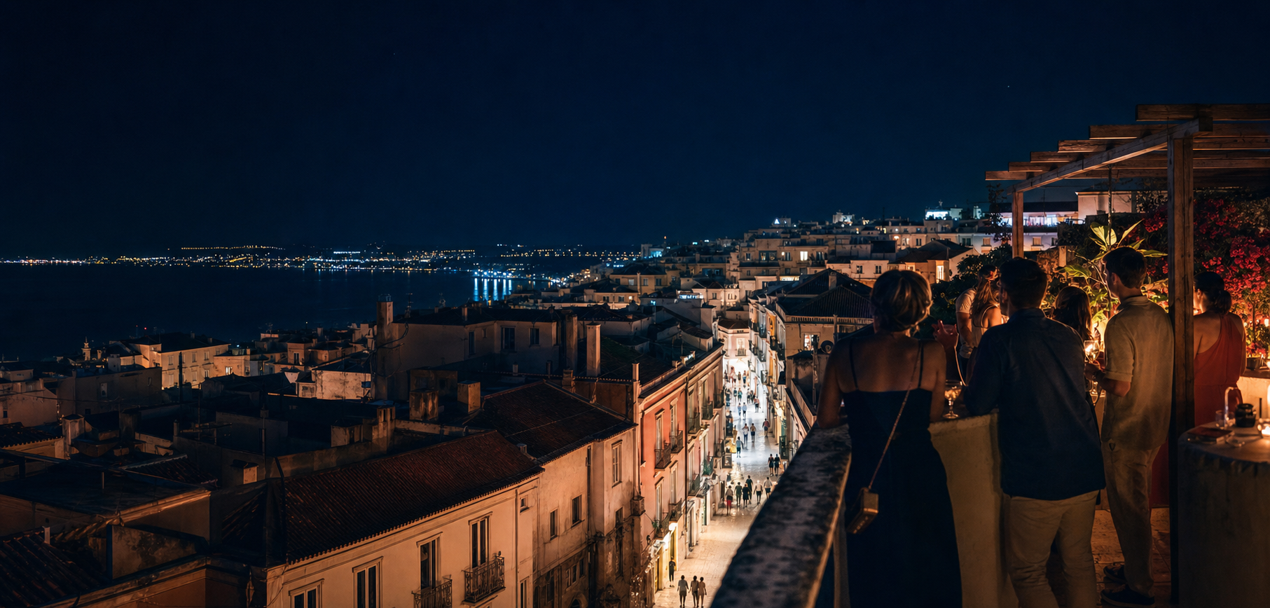 Nächtlicher Blick über eine europäische Küstenstadt von einer Dachterrasse